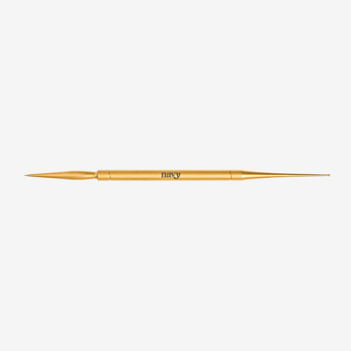 Gold detailing tool with 'Navy' branding on a white background