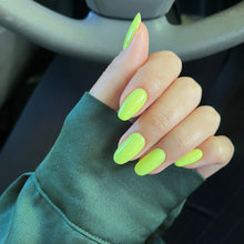 Charger l'image dans la galerie, Hand with neon green nails wearing a green sleeve, blurred background