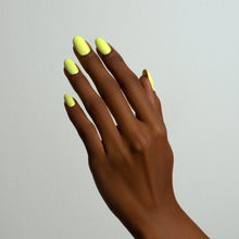 Charger l'image dans la galerie, Hand with bright yellow nail polish on a plain background