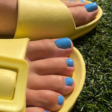 Charger l'image dans la galerie, Yellow sandals worn on feet with blue nail polish against a grass background