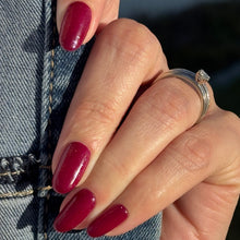 Charger l'image dans la galerie, A close-up of a hand with glossy deep berry red manicured nails, wearing a silver ring and resting against a blue denim jacket.