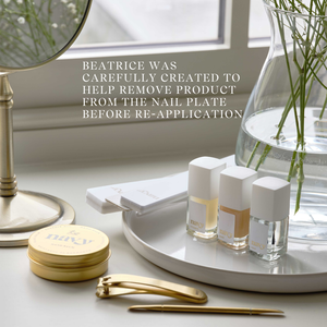 Nail care products and tools on a white surface with text about a product called Beatrice.
