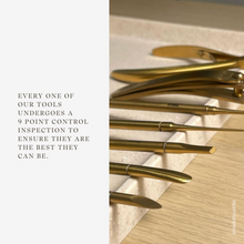 Load image into Gallery viewer, Gold tools arranged on a wooden surface with text about quality control.