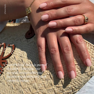 Close-up of two hands with pink nail polish on a woven surface, with text overlay.