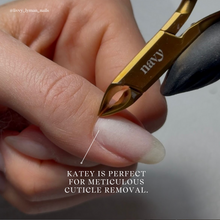Load image into Gallery viewer, Close-up of a hand using a cuticle nipper with &#39;navy&#39; branding on a neutral background.