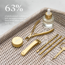 Load image into Gallery viewer, Set of gold beauty tools on a textured surface with a bottle of serum.