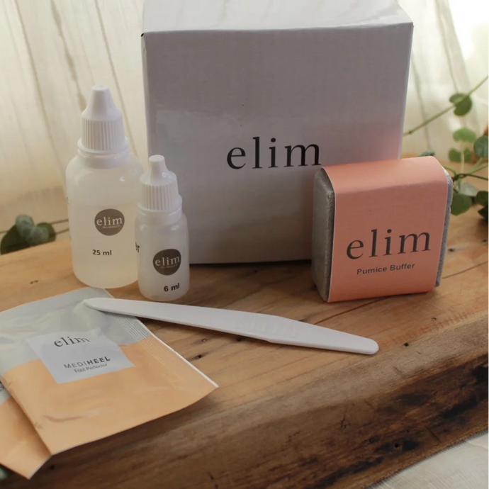 Elim skincare products including bottles, a box, and packets on a wooden surface.